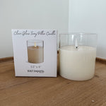 Clear glass ivory pillar candle with packaging on a wooden surface