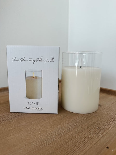Clear glass candle with packaging on a wooden surface