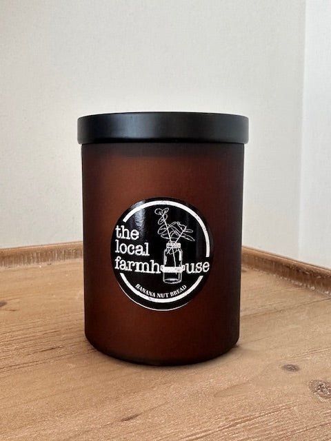 Black cylindrical container with black lid on a wooden surface