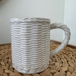 White textured bag with a handle on a woven surface