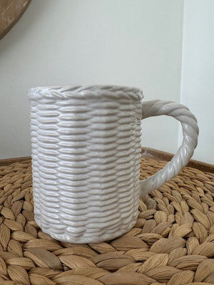 White textured bag with a handle on a woven surface