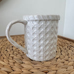 White textured mug on a woven mat