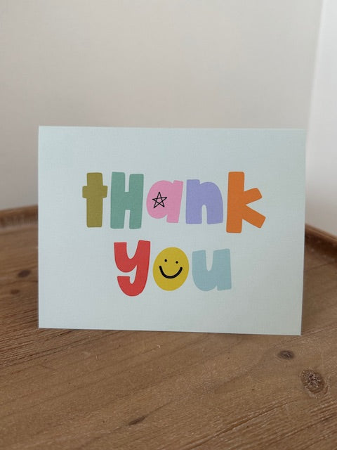 Colorful card with 'Happy' text on a wooden surface
