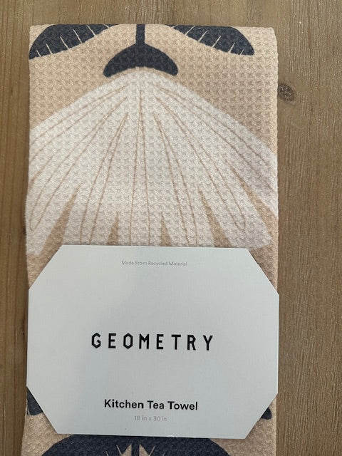 Patterned kitchen tea towel with a label on a wooden surface