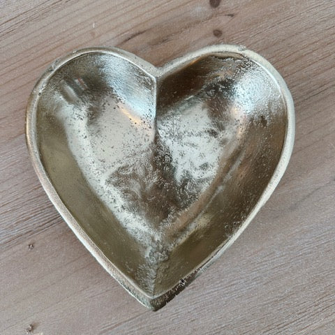 Heart-shaped metal dish on a wooden surface