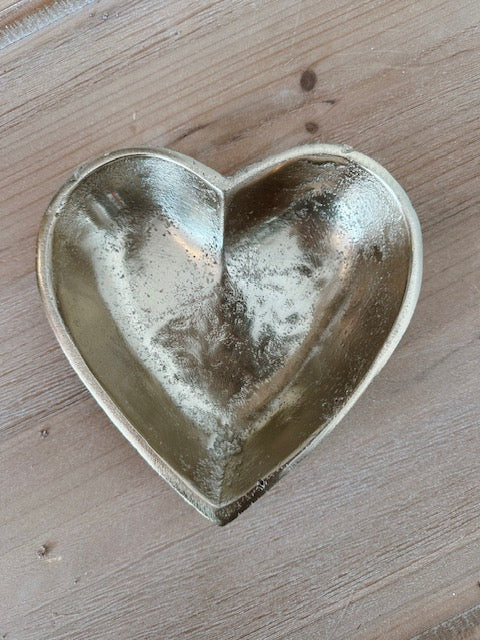 Heart-shaped metal dish on a wooden surface