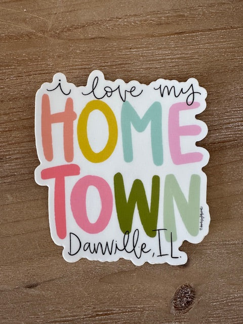 Colorful sticker with text 'I love my hometown Danville, IL' on a wooden surface