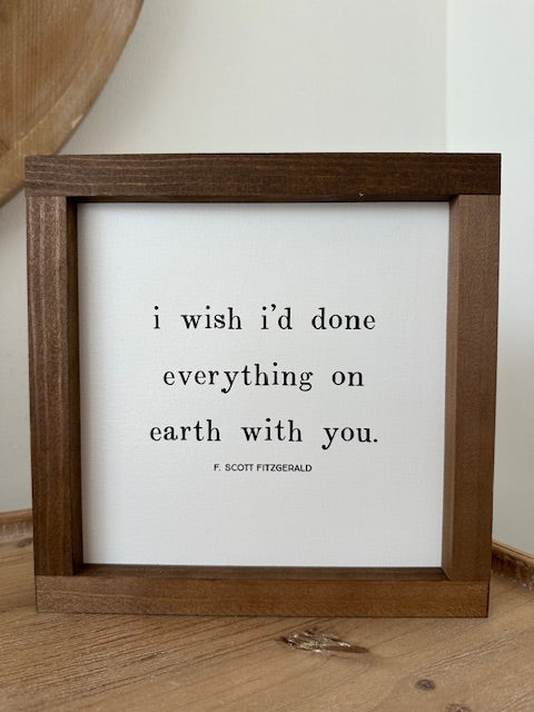 Framed quote by F. Scott Fitzgerald on a wooden surface