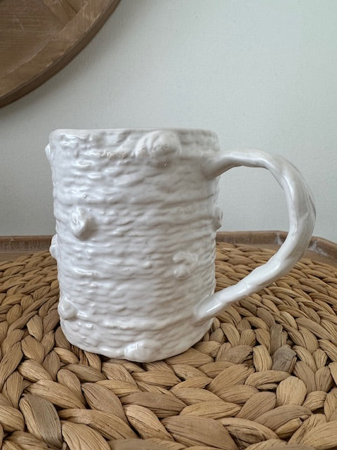 White textured ceramic handbag on a woven surface