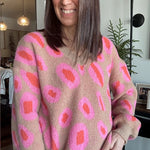 Person wearing a pink and beige patterned sweater indoors.