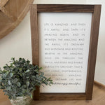 Framed motivational quote on a wall with decorative elements