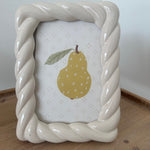 Decorative soap dish with a pear design on a wooden surface