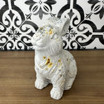 A white concrete rabbit statue with a textured coat and rustic distressed finish, featuring sporadic rusty accents.